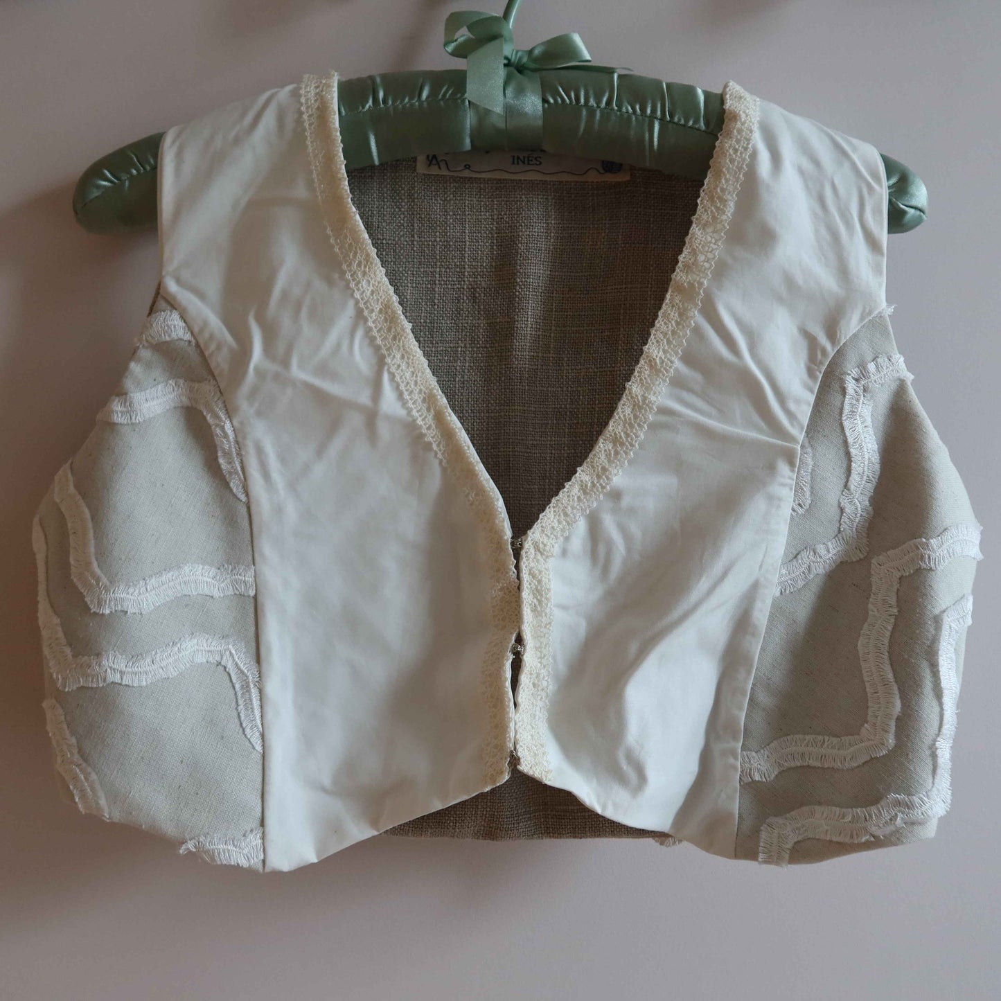 Cropped vest - reversible linen cotton vest with vintage lace trim, showcasing up-cycled fashion in neutral tones on padded hanger.