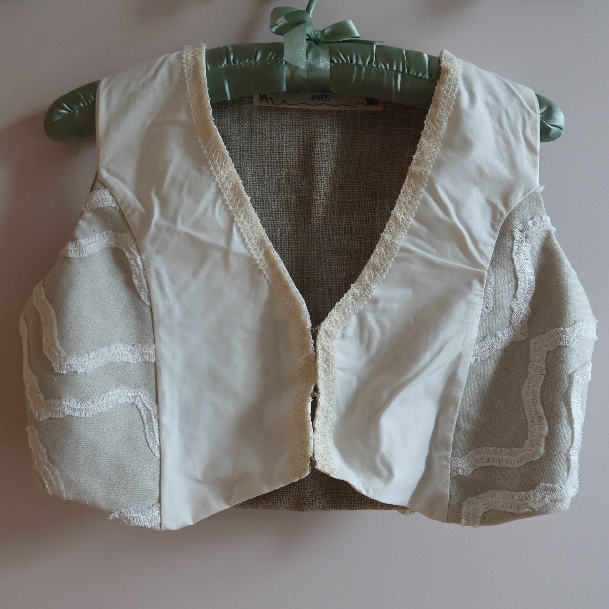 Cropped vest - reversible linen cotton vest with vintage lace trim, showcasing up-cycled fashion in neutral tones on padded hanger.
